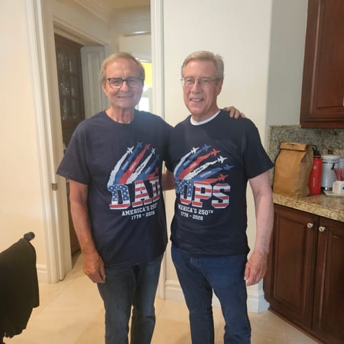 Two customers wearing matching patriotic 'Dad' and 'Pops' t-shirts celebrating America's 250th birthday.