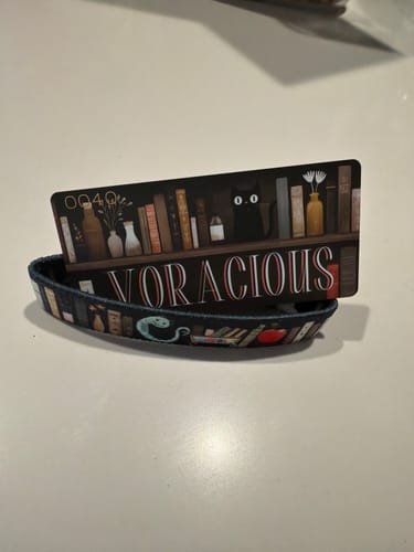 Customer's Voracious Bracelet displayed with its matching collector's card on a white surface.