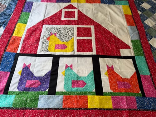 Customer's completed quilt made from the Funky Chickens kit, showing a red barn and four colorful chickens.