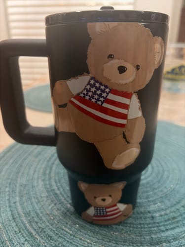 Customer's black Thicc Buddy Stars & Snuggles mug, showing a raised teddy bear wearing a patriotic shirt.