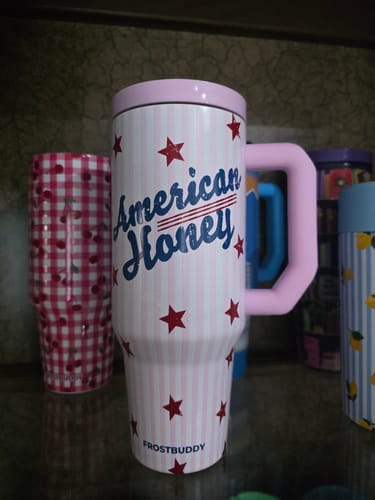 Customer's Thicc Buddy 40oz American Honey mug with a patriotic striped design and pink handle, displayed on a shelf.