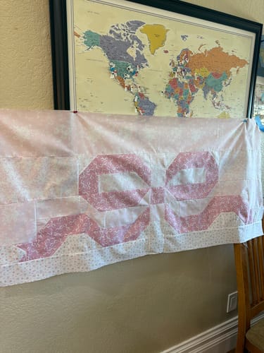 Customer's Love Blossoms quilt in progress, showing a pieced pink bow design.