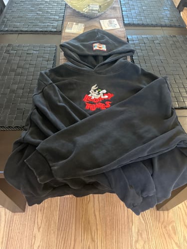 Customer's faded black Looney Tunes Embroidered Hoodie laid out on a table, showing the Bugs Bunny chest graphic.