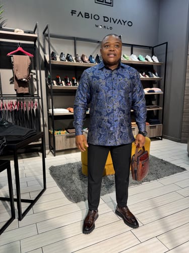 Customer holding the SKARLET061 brown leather side bag while standing in a clothing store.