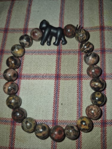 Customer's Traverse Bracelet with a black gorilla charm and multicolored stone beads laid out flat.