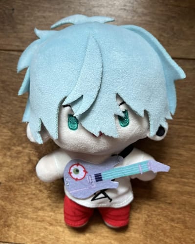 Customer's Alien Stage plush toy with light blue hair, holding a small purple guitar toy.