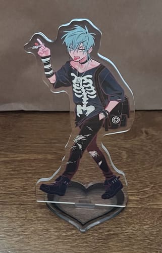 Customer's Alien Stage Till acrylic standee featuring a stylized character in a skeleton shirt, standing on a heart base.