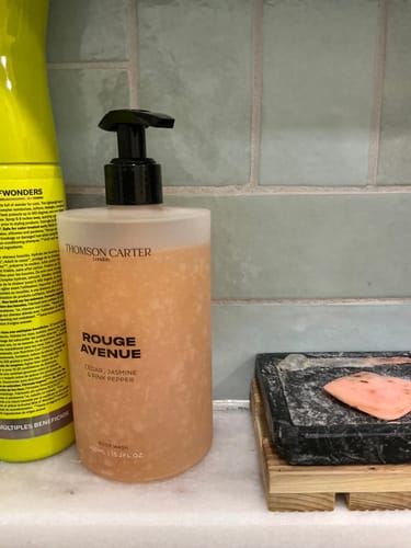 Customer's Rouge Avenue body wash bottle on a bathroom counter next to a soap dish.
