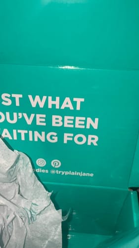 Customer's teal shipping box for Jungle Driver THCA Flower, partially empty with white packing paper.