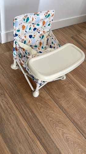 Customer's Charlie baby chair with a white tray, featuring a colorful patterned fabric sitting on a wooden floor.