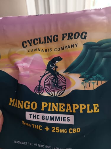Customer's packaging for Mango-Pineapple THC Gummies featuring a frog on a bicycle against a tropical sunset background.