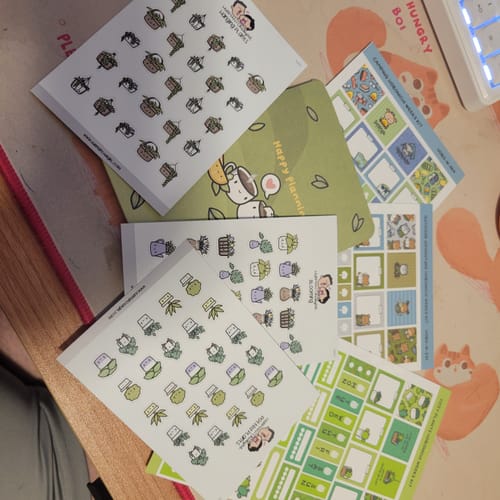 Customer's Cozy Plants Theme Hobonichi Weeks Kit sheets with plant illustrations spread out on a flat surface.