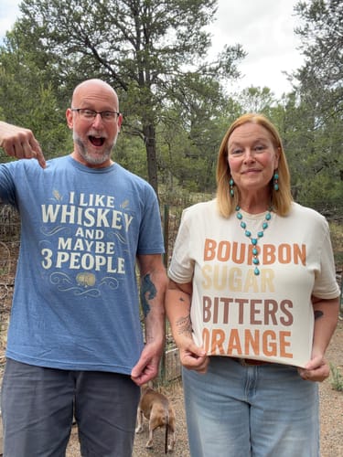 Customer's Bourbon Sugar Bitters Orange T-Shirt, worn by a man and woman outdoors with a dog.