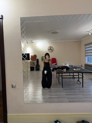 Reviewer's black baggy snow pants, worn in a mirror selfie at home, showing a loose, relaxed fit.
