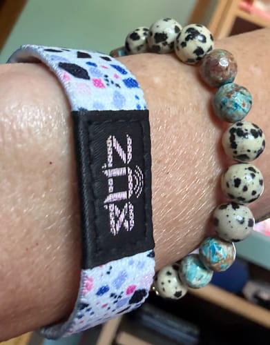 Customer's Know Your Worth bracelet with a patterned fabric strap featuring the ZOX logo on a black tag.