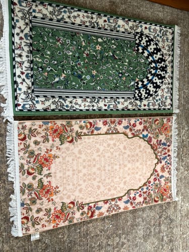Customer's two Barakah Padded Prayer Mats on the floor. One is a green mat with floral patterns, and the other is beige with florals.