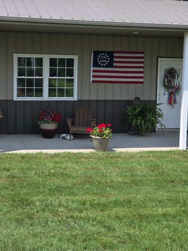 Customer's embroidered 1776 to 2026 Betsy Ross Flag hanging on the wall of their covered porch.