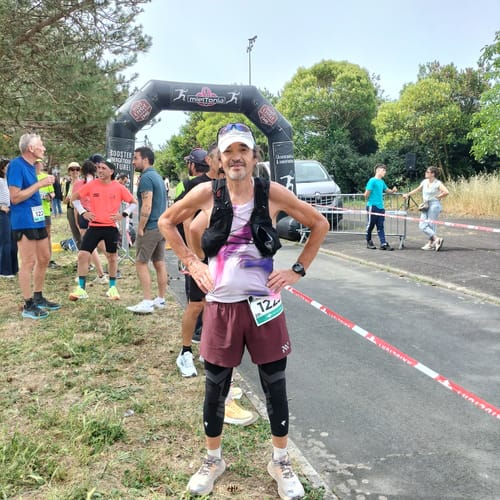 Client portant le maintien de compression noir pour genoux et jambes à une ligne d'arrivée de course.