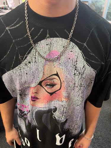 Customer's silver Aries Chain necklace worn around the neck over a graphic t-shirt.