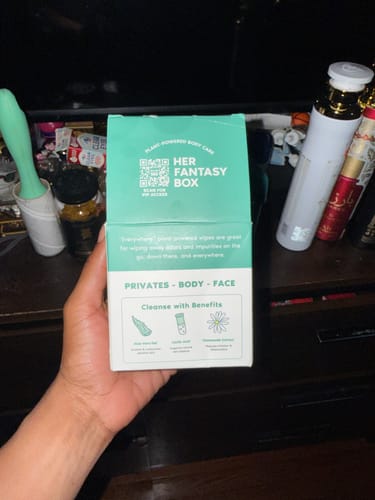 Reviewer holding the teal box of Everywhere Wipes, showing product details for private, body, and face use.