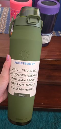 Reviewer's hand holding a matte moss green Mystery Bottle Buddy with white product labeling