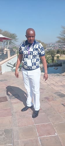 Customer's LFN007 knit top with bold graphic pattern, paired with white trousers outdoors.