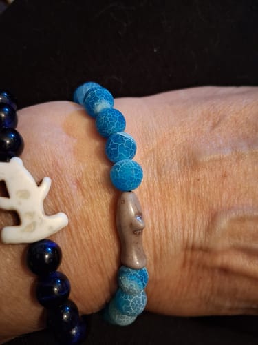 Reviewer's wrist wearing a Shark Week Bracelet with blue cracked beads and a shark charm alongside another bracelet.