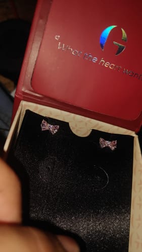 Customer's pair of pink bow stud earrings inside a GIVA branded jewelry box.