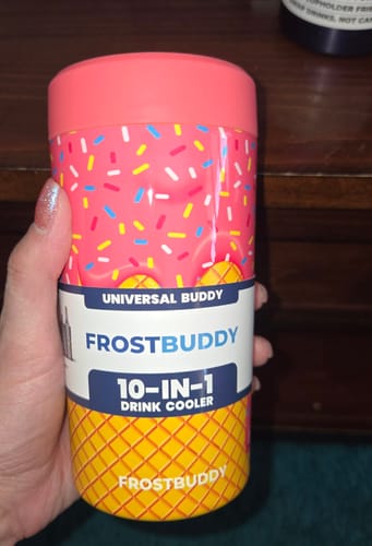 Customer's hand holding a pink ice cream cone patterned Universal Buddy drink cooler.