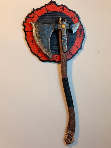 Customer's Leviathan Kratos axe mounted on a circular red and black wooden display on a wall.