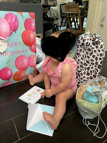 Customer's Ella portable booster chair in a matching leopard print carry bag on the floor next to a child.