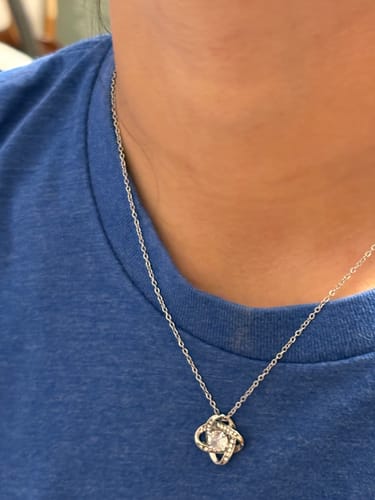 A customer wearing the silver-colored Love Knot Necklace from the gift set.
