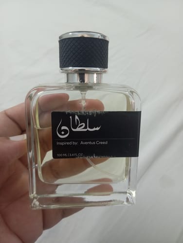 Customer holding the square glass bottle of Sultan (سلطان) perfume.