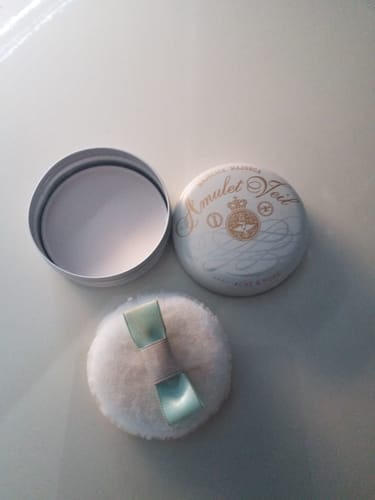 Reviewer's open tin of Majolica Majorca Amulet Veil powder with its lid and fluffy puff applicator.