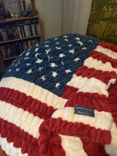 Customer's plush Hugs Flag Blanket bunched up to show its soft texture and American flag design.