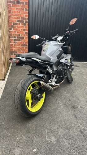 Customer's grey Yamaha MT10 motorcycle with bright yellow wheels parked outdoors.