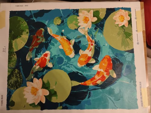 Ein Kunde zeigt das fast fertige "Malen nach Zahlen - Koi-Teich" mit farbenfrohen Fischen und Seerosen.