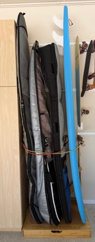 Customer's Spirit Rack made of bamboo holding four surfboards in bags, showing the floor-standing design.