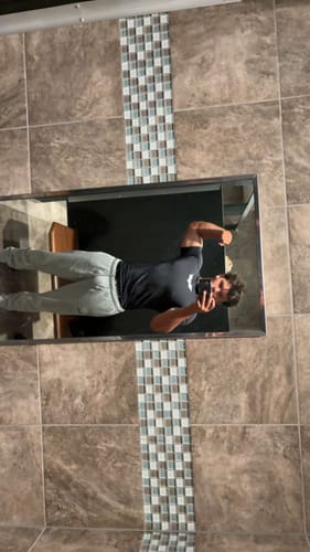 Reviewer's Batman Compression Tee, black, worn while posing and taking a selfie in a tiled mirror.