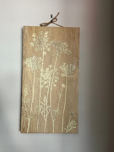 Customer's Hughette wood block wall art hanging on a white wall, featuring white wildflower prints on natural timber.