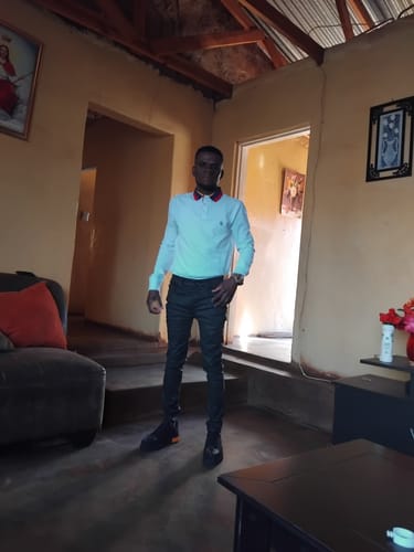 Customer's LUFIANO leather sneakers in black worn while standing in a living room.