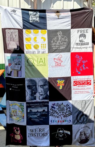 Customer's Premium T Shirt Quilt showcasing a grid of various graphic t-shirt panels, held up vertically.