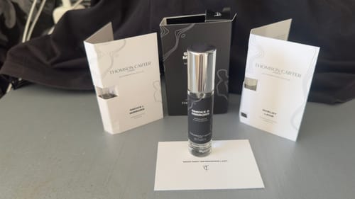 Customer's small Smoke & Mirrors bottle with packaging and brand leaflets on a grey surface.