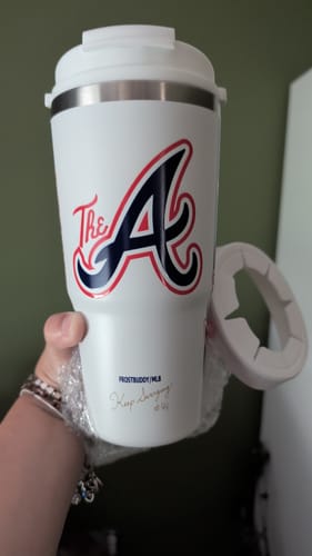 Customer's white Atlanta Braves To-Go Buddy cup being held in hand with the detachable lid ring visible.