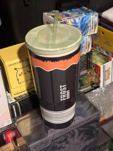Customer's Mystery To-Go Buddy cup with a dark and orange design sitting on top of various boxes.