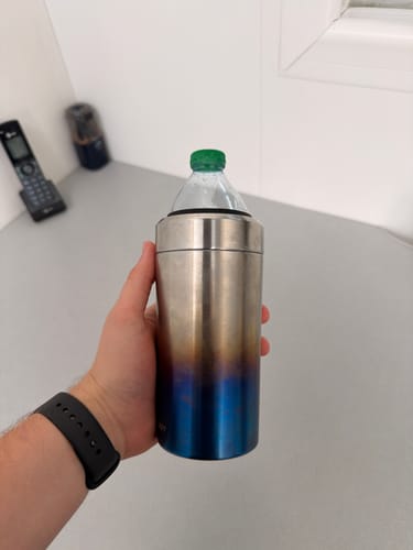 Customer's hand holding a Universal Buddy can cooler in burnt titanium, containing a plastic water bottle.