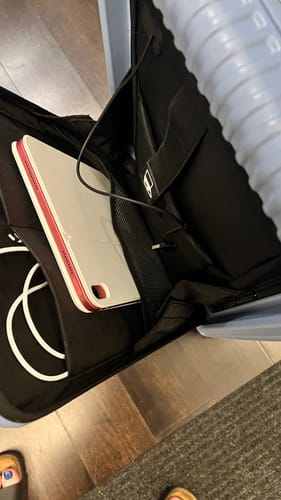 Reviewer's open All-in-One Carry-On showing a tablet and charging cable inside the front laptop compartment.