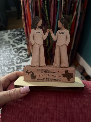 Customer's wooden plaque featuring two figures pinky-promising with states and a heartfelt message on the base.