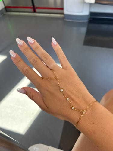 Customer's gold-toned hand bracelet with crystal stones worn on a hand.