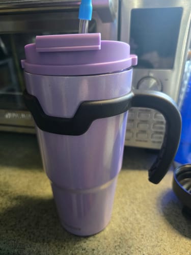 Customer's purple To-Go Buddy tumbler with black handle and straw, sitting on a kitchen counter.